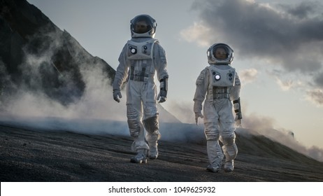 Dva astronauti ve vesmírných oblecích sebevědomě kráčejí po cizí planetě, průzkum povrchu planety. Na výzkumné základně/stanici a Roveru. Vesmírné cestování, kolonizační koncept.