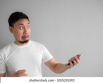 Khuôn mặt kinh ngạc và đáng sợ của người đàn ông châu Á bị hét lên từ điện thoại thông minh. Nhìn thấy một cái gì đó đáng sợ trong điện thoại thông minh.