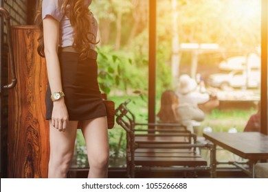 La joven estaba sola en la cafetería esperando con ansias al joven que había arreglado para ella después de la escuela por la noche para comer e irse a casa. Fondo borroso de la naturaleza y la luz del sol.
