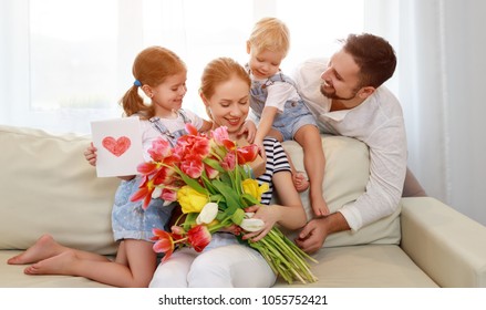 Selamat Hari Ibu! ayah dan anak-anak mengucapkan selamat kepada ibu pada hari libur dan memberi bunga