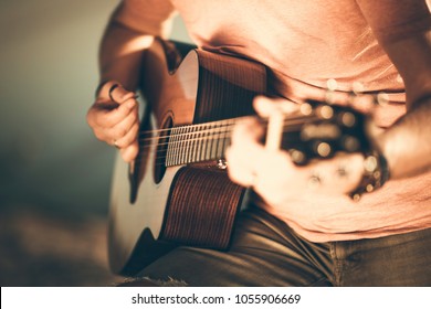 Caucasian Guitarist Playing Acoustic Guitar. Closeup Music String Instrument Theme.