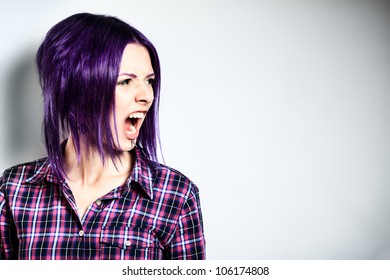 Portrait of a aggressive punk girl with purple hair.