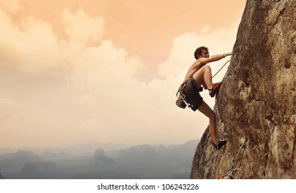 Jonge man klimmen op een kalkstenen muur met brede vallei op de achtergrond