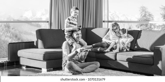 Glécklech Famill. Papp, Mamm a Kanner spillen e Videospill Papp a Jong spillen Videospiller zesummen um Buedem