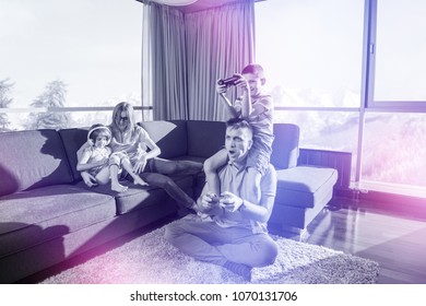 Glécklech Famill. Papp, Mamm a Kanner spillen e Videospill Papp a Jong spillen Videospiller zesummen um Buedem