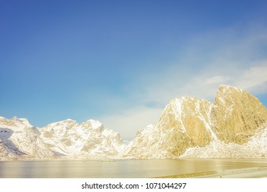 Outdoor view of mountain peaks covered with snow during winter in gorgeous blue sky Olenilsoya in Reine, Lofoten Islands, Norway