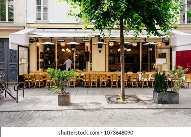 Cozy street with tables of cafe in Paris, France. Architecture and landmarks of Paris. Postcard of Paris