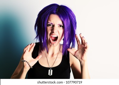 Portrait of a aggressive punk girl with purple hair.