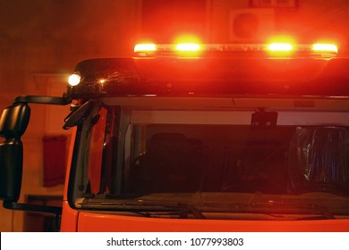 Rote Ampeln eines Feuerwehrautos. Nachtzeit. Feuerwehrauto. Das Feuer löschen. Nahaufnahme der roten Lichter oben auf einem Feuerwehrauto.