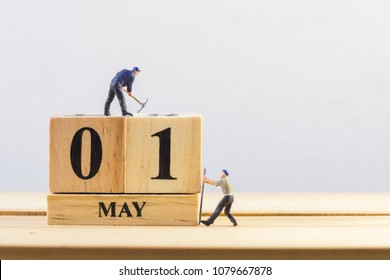 1 mei. Dag 1 van de maand. Miniatuur werknemer houten blok kalender. het concept van de dag van de arbeid.
