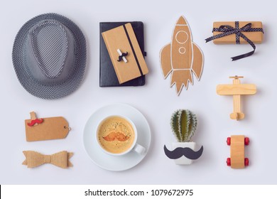 Fathers day concept with hat, coffee cup, notebook and gifts on white background. View from above. Flat lay