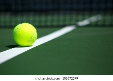 Tennisbal op het veld met het net op de achtergrond