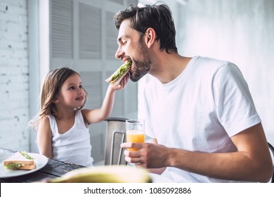 Ich liebe dich Papa! Ein hübscher junger Mann zu Hause mit seinem kleinen süßen Mädchen frühstückt. Alles gute zum Vatertag!