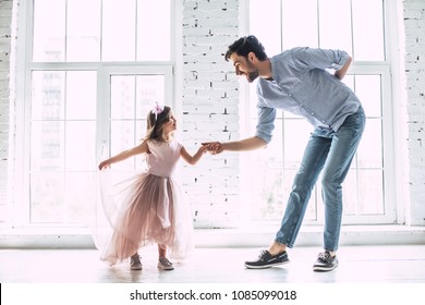 ¡Te amo, papá! Un joven apuesto baila en casa con su linda niña. ¡Feliz Día del Padre!