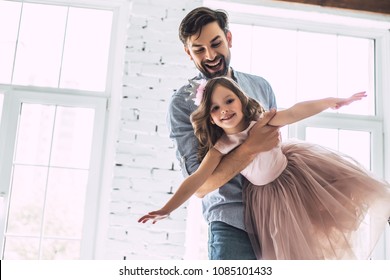 Ich liebe dich Papa! Ein hübscher junger Mann tanzt zu Hause mit seinem kleinen süßen Mädchen. Alles gute zum Vatertag!
