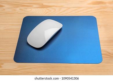 Blank pad and wireless computer mouse on wooden background