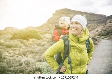 Super-Mutter mit Baby im Rucksack unterwegs. Mutter auf Wanderabenteuer mit Kind, Familienausflug in die Berge. Urlaubsreise mit Kleinkind auf dem Rücken, Wochenendreise auf Teneriffa, Spanien.
