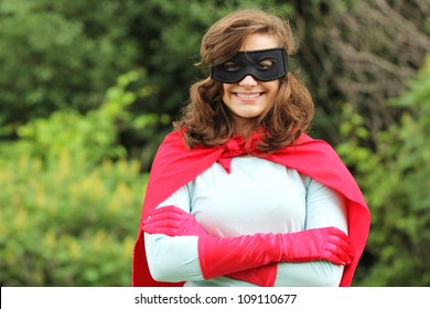 Giovane donna con kit da supereroi rosso sorridente