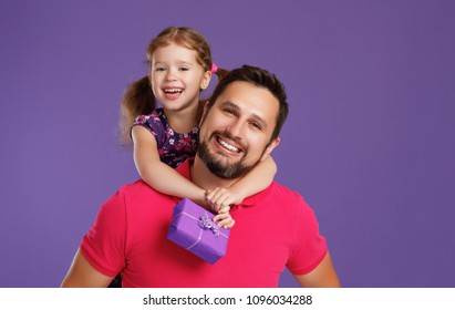 happy father's day! cute dad and daughter hugging on colored violet background