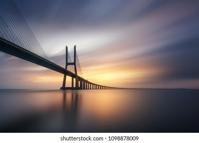 Lang eksponeringsfotografering på Vasco da Gama-broen i Lissabon ved solopgang