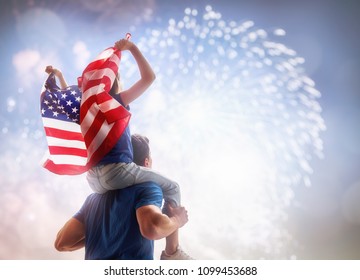 Ngày lễ yêu nước. Đứa trẻ ngồi trên vai của cha cô và cầm lá cờ của Hoa Kỳ. Mỹ kỷ niệm ngày 4 tháng 7.