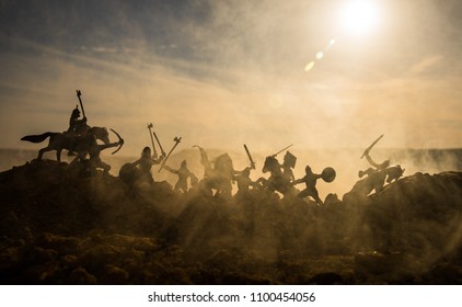 騎兵と歩兵による中世の戦闘シーン。個別のオブジェクトとしての人物のシルエットは、日没の霧の背景に戦士の間で戦います。セレクティブ フォーカス