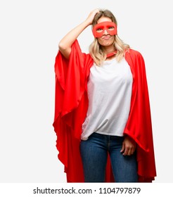 Jonge superheldin met cape, twijfelende uitdrukking, verwarrend en verwonderd concept, onzekere toekomst
