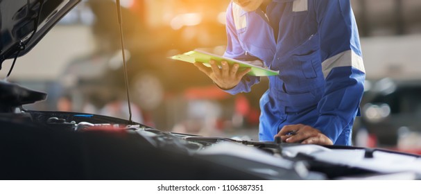 車のサービス、修理、メンテナンスのコンセプト – アジアの自動車整備士またはスミスがワークショップの倉庫でクリップボードに書き込み、技術者がガレージで車の修理のチェックリストを作成、バナー