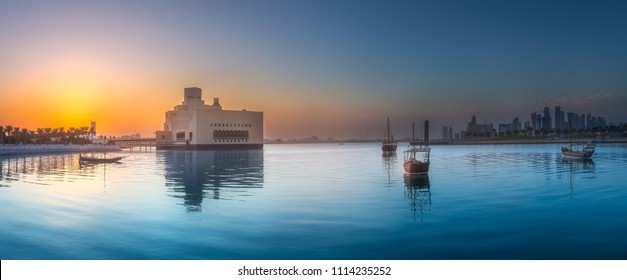 ドーハ公園の海辺とボート、カタールで紫色の日没時にイースト マウンド スカイライン ビュー。