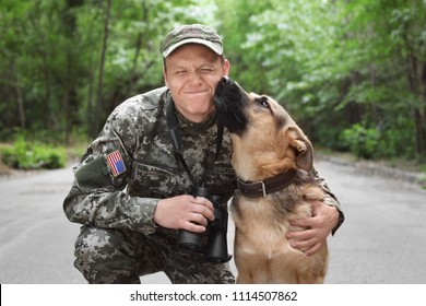 Man in militair uniform met Duitse herdershond, buitenshuis