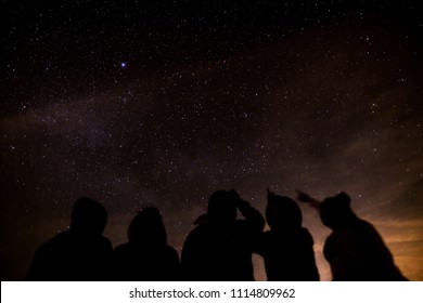 Silueta de un grupo de amigos mirando las estrellas