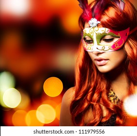 Maskerade. Schönes Mädchen in einer Karnevalsmaske über dem blinkenden Hintergrund des Feiertags. Bokeh