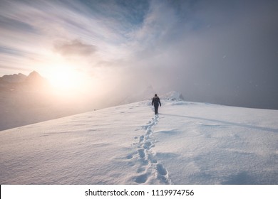 Seorang pendaki gunung berjalan dengan jejak salju di puncak punggungan di musim dingin