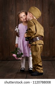 djeca dječak su obučeni kao vojnici u retro vojnim uniformama i djevojčica u ružičastoj haljini