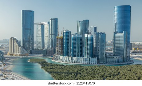 Buildings on Al Reem island in Abu Dhabi timelapse from above. Aerial citiscape of Al Reem Island at morning, showing the reflection on skyscrapers.