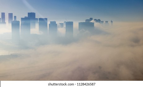 アラブ首長国連邦の最大かつ最も人口の多い都市、朝のアブダビの通りのタイムラプスで、濃い霧の下のスカイライン。日の出後の高層ビルの空撮