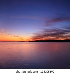 Beweging tijdens deze lange belichting creëert penseelstreekwolken net na zonsondergang boven Gloucester Bay; Gloucester, Massachusetts