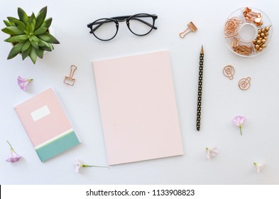 Flache Lage, Draufsicht Bürotisch Schreibtisch Arbeitsbereich mit Bürozubehör einschließlich leerem Papier für Schriftzug, Notizblock, Brille und Pflanze auf weißem Hintergrund. Attrappe, Lehrmodell, Simulation
