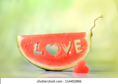 Frische saftige Wassermelonenscheibe auf natürlicher grüner Hintergrundnahaufnahme mit Liebesbriefwort