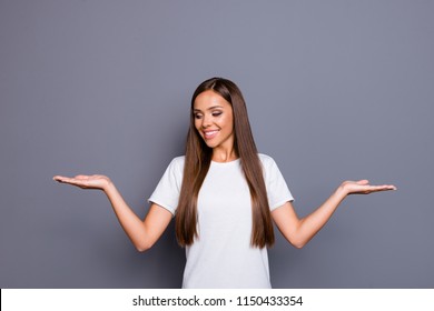 Portrait of brown-haired gorgeous attractive nice young lady, showing gesture with palms, choosing options, balance, over grey background, isolated