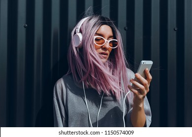 Young beauty girl purple hair make selfie on smartphone, happy face, outdoor hipster portrait on the street, smile happy face, listen music on headphones, Amsterdam street, dance, player,photo concept