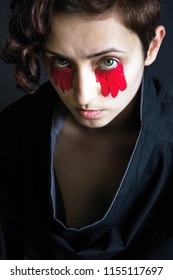 foto modni portret djevojke u crnoj odjeći s crvenom bojom ispod očiju
