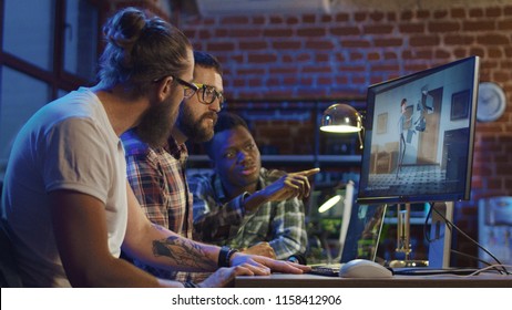 Side view of diverse group of men sitting at table with computer and coworking on creation of new cartoon