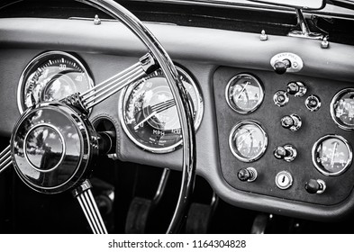 Volante y salpicadero en un histórico coche rojo vintage. Escena interior de automóvil retro. Viejo vehículo. Tema de conducción. foto en blanco y negro.