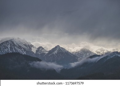 Bergen bedekt met sneeuw met donkere bewolkte lucht in regenachtige dag