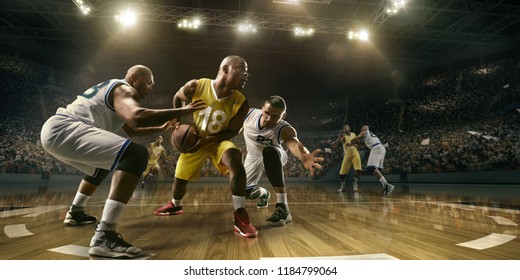 Basketballspieler auf großer professioneller Arena während des Spiels. Spannender Moment des Spiels. Männliche kaukasische und schwarze Spieler kämpfen um den Ball