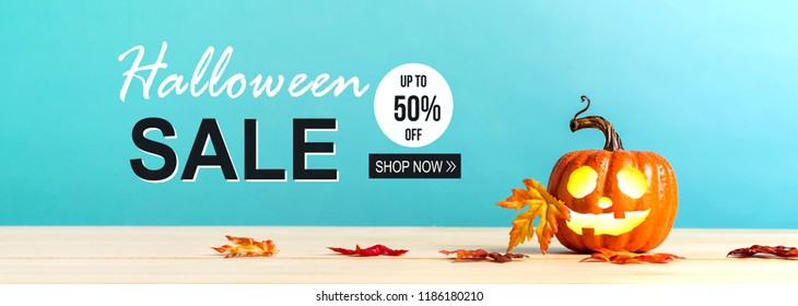 Halloween sale message with pumpkin with leaves on a blue background