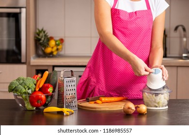 キッチン カウンターのタマネギ チョッパーをオンにする女性の手の詳細。キッチンでお弁当を作り、玉ねぎのみじん切りをする女性
