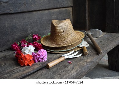 Strohoeden, tuingereedschap en vers gesneden bloemen