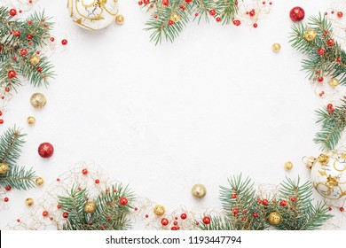 Heller Weihnachtsrahmen aus Fichten-, Rot- und Goldweihnachtsdekorationen auf weißem Hintergrund. Platz kopieren. Winterferien, Neujahr.